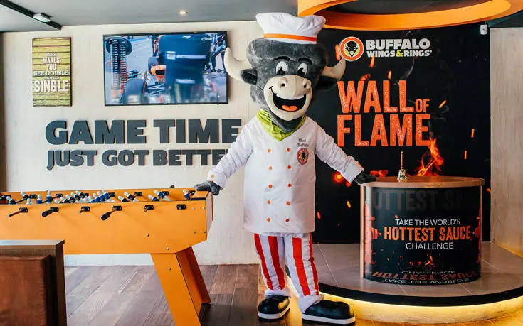 Chef-Buffalo-Mascot-Action-Picture.jpg Chef Buffalo mascot costume in a restaurant.