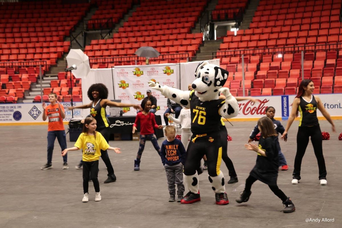Tri-Cities-Fire-Sparky-Maskottchen Dalmatiner-Maskottchen tanzt mit Kindern bei einer Sportveranstaltung