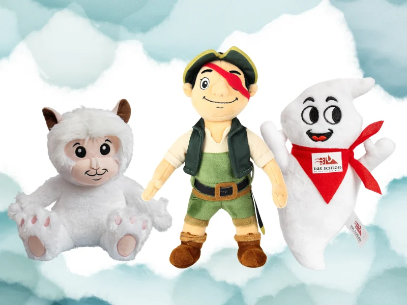 Three plush toy characters: a fluffy white creature, a pirate explorer, and a smiling ghost with a red scarf against a cloudy blue background.